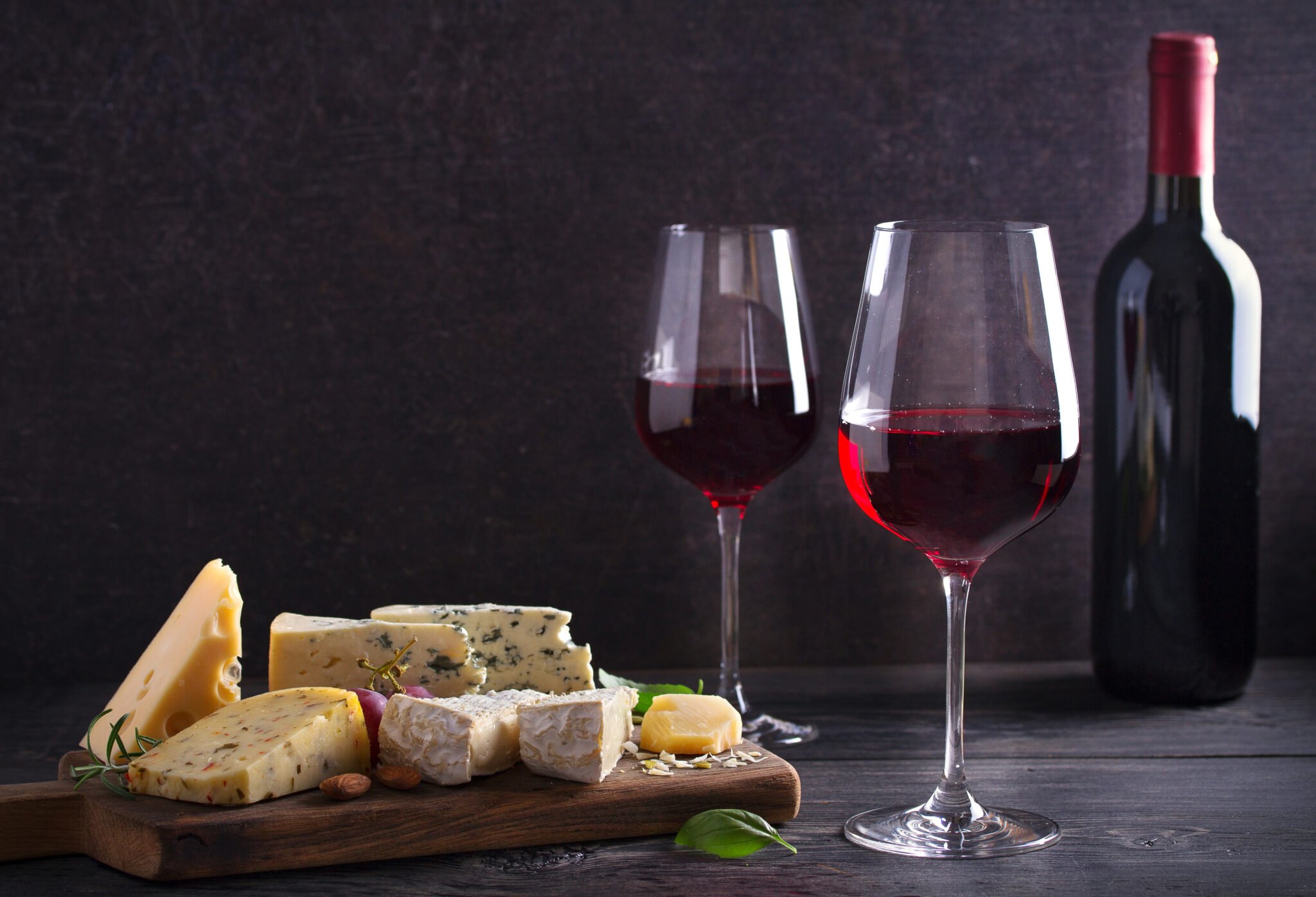 Red wine with cheese on chopping board. Wine and food concept